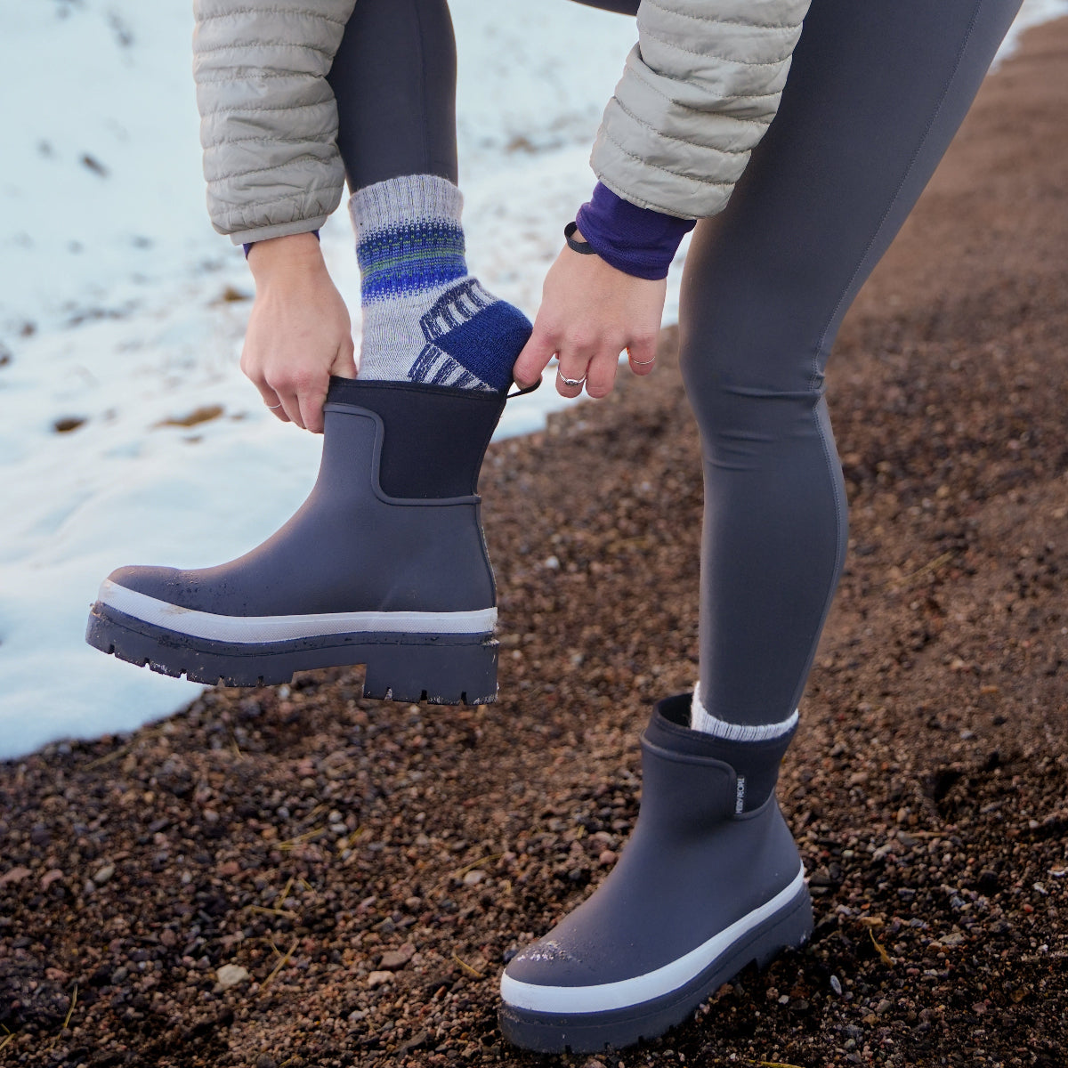 White hiking socks in mountains putting boot on