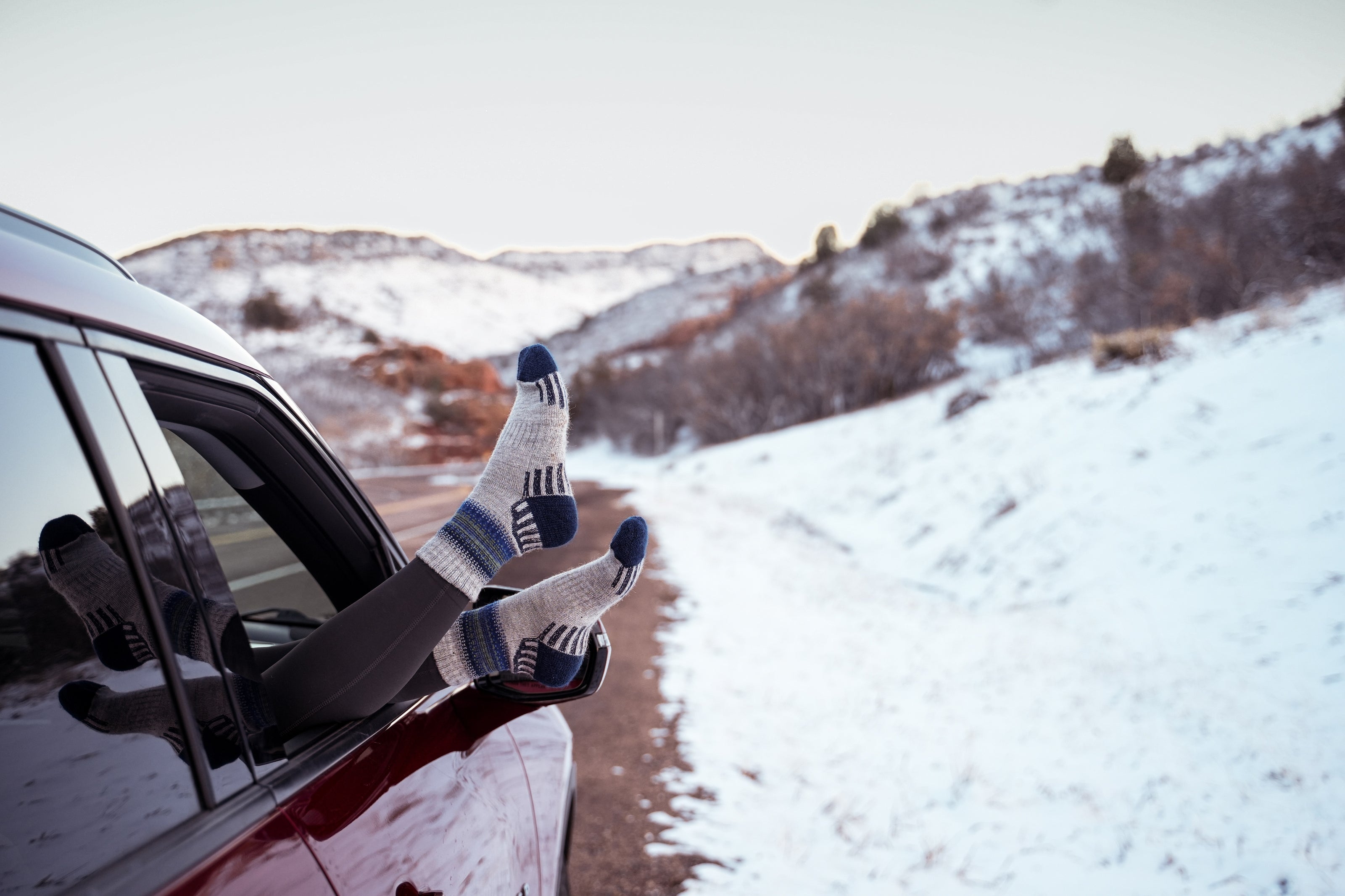 White hiking socks sticking out of car snow mountains